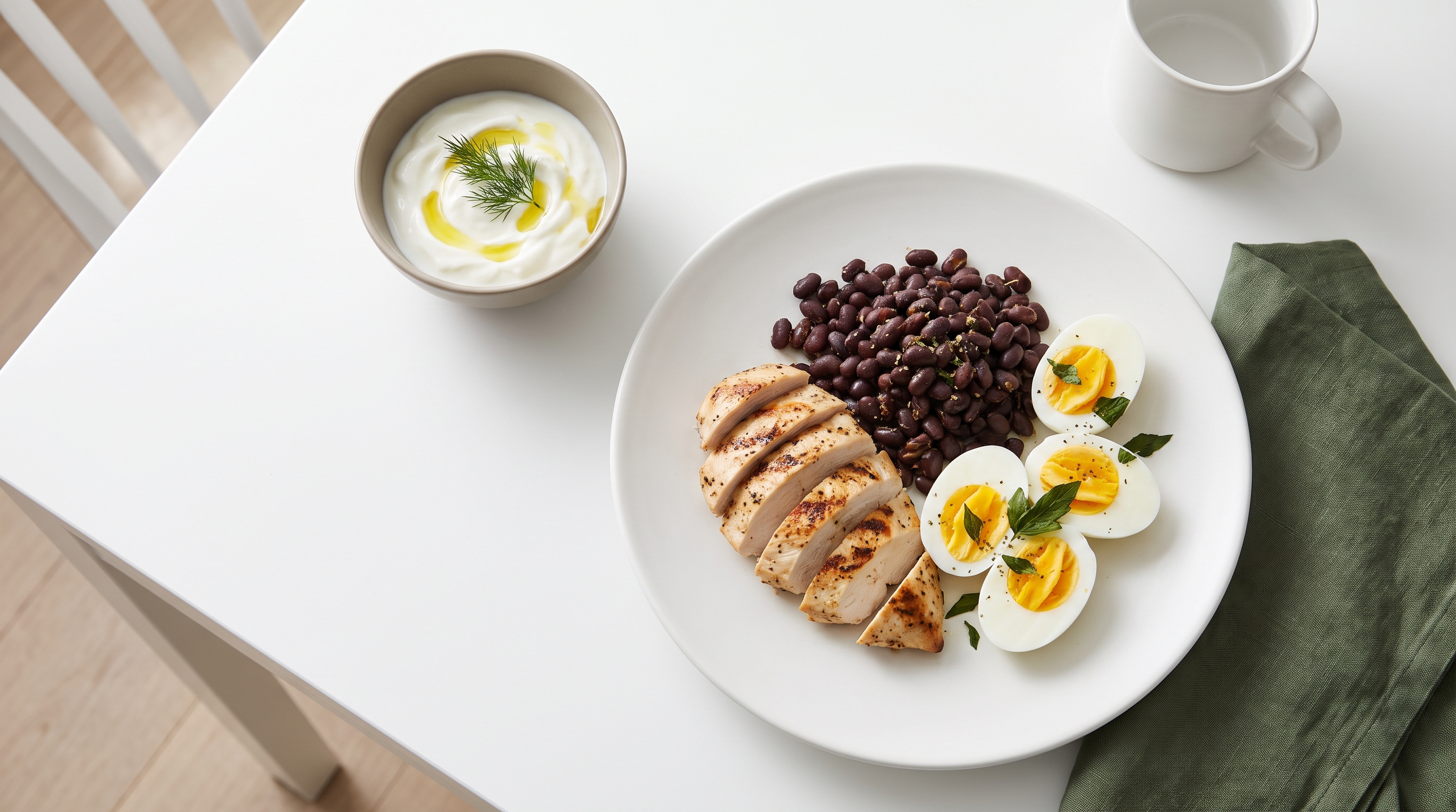 grilled chicken, beans, eggs and yoghurt on a kitchen table