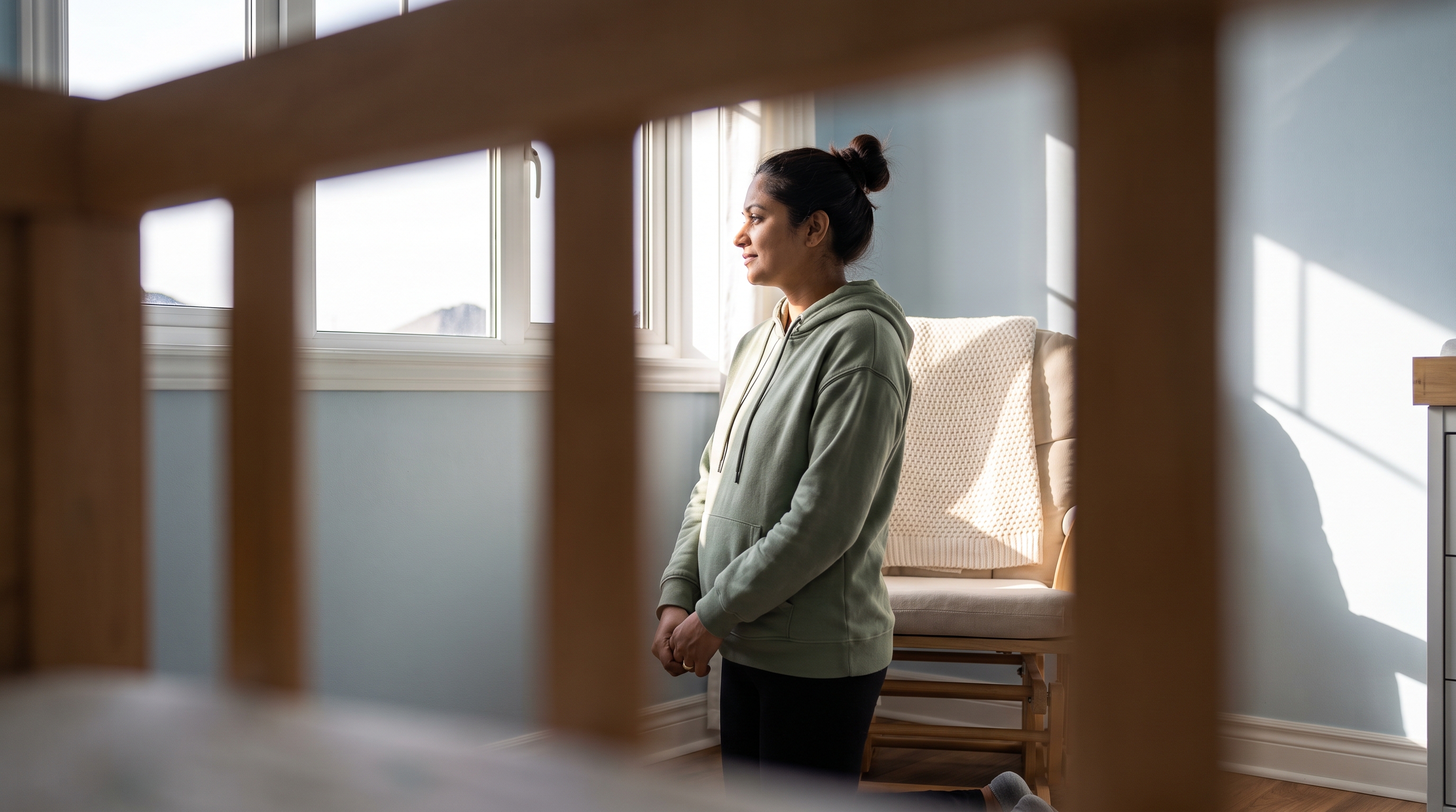 A mother in her early 30s in a cozy nursery in the evening