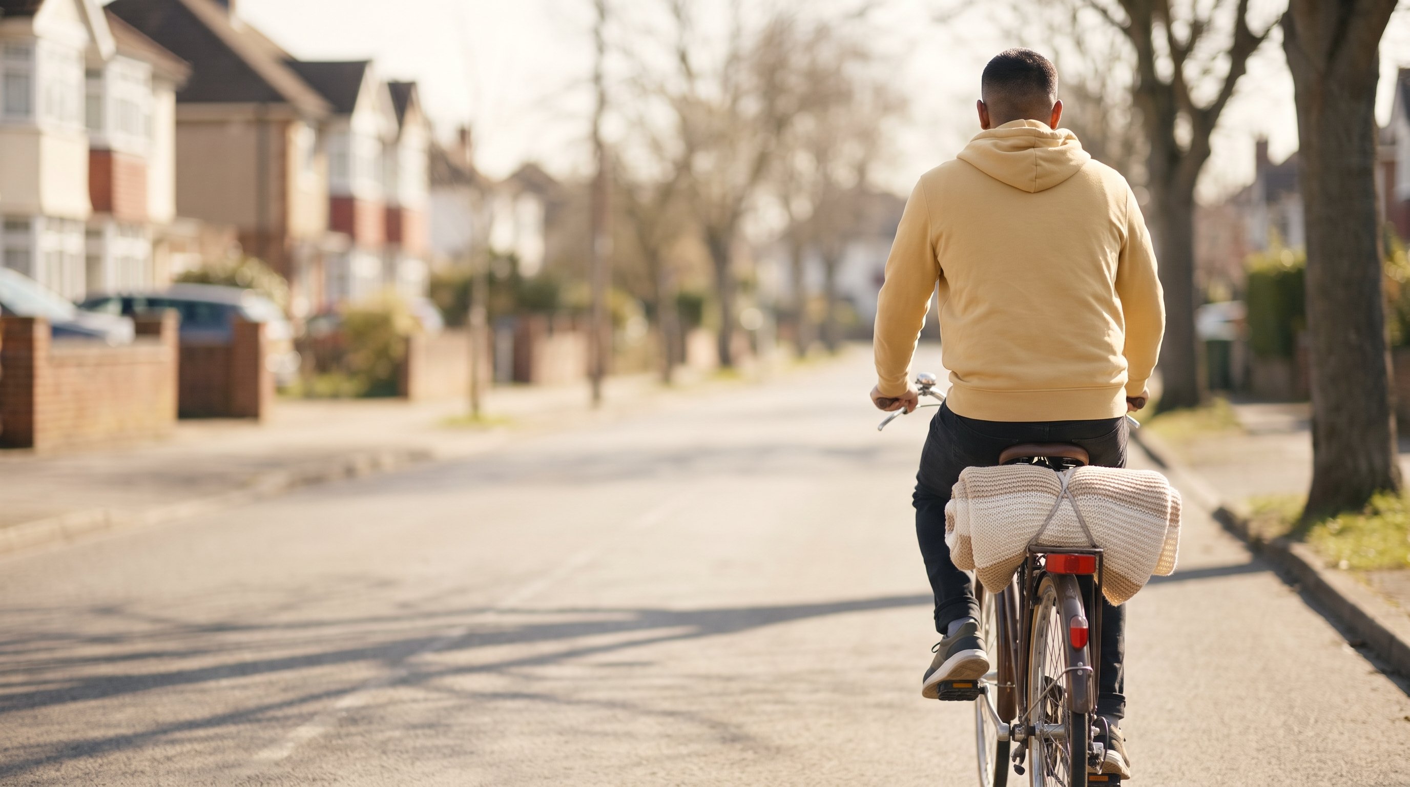 Man cycling on a quiet residential street in the early evening
