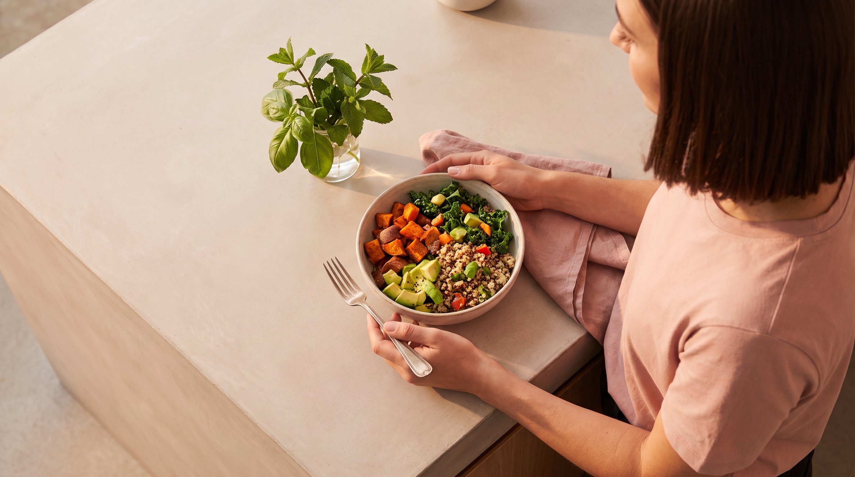 woman preparing a simple vegetable and grain bowl in a home kitchen