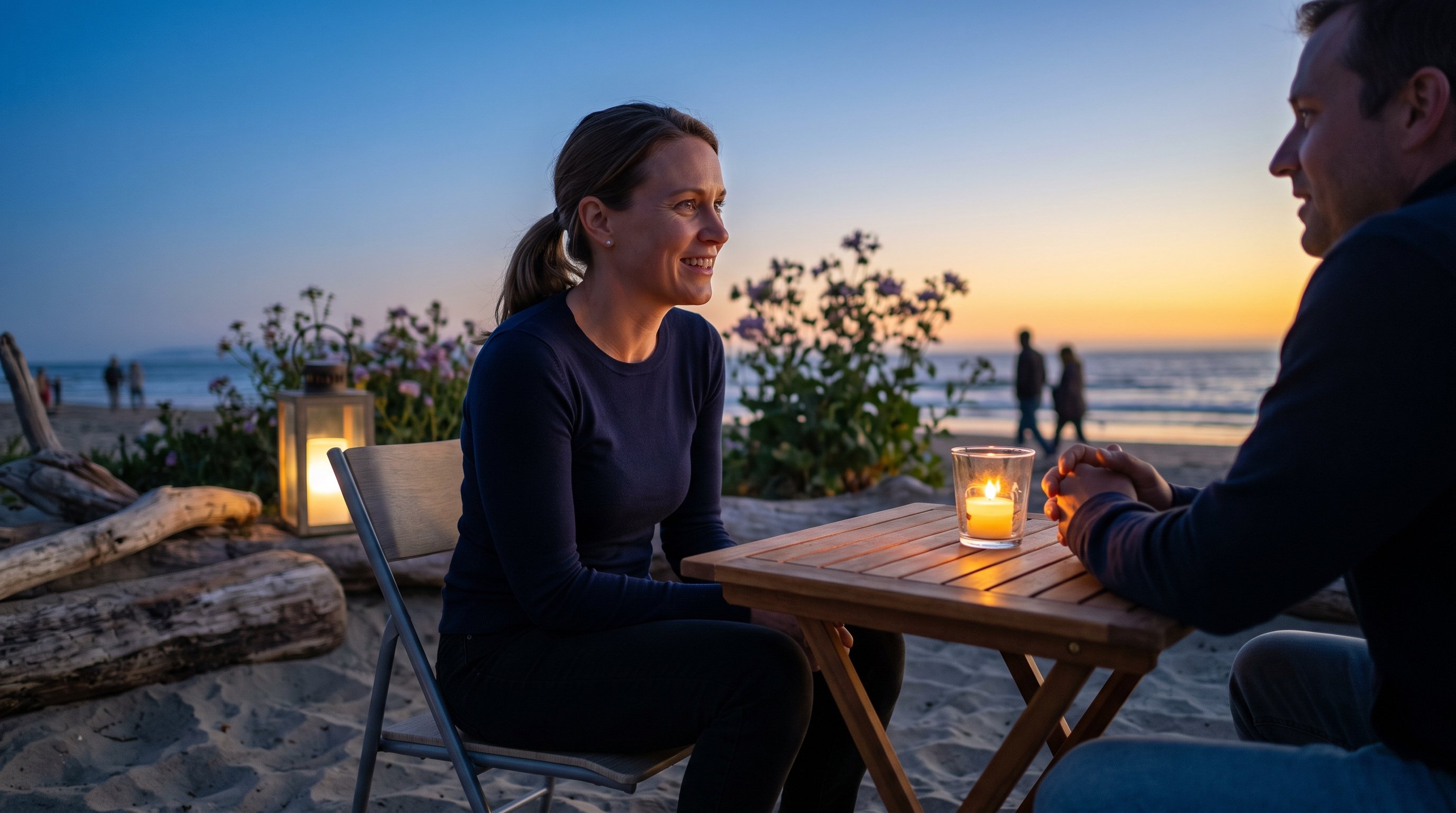 A man and woman in their 30s talking over candlelight at a small cafe table in the evening