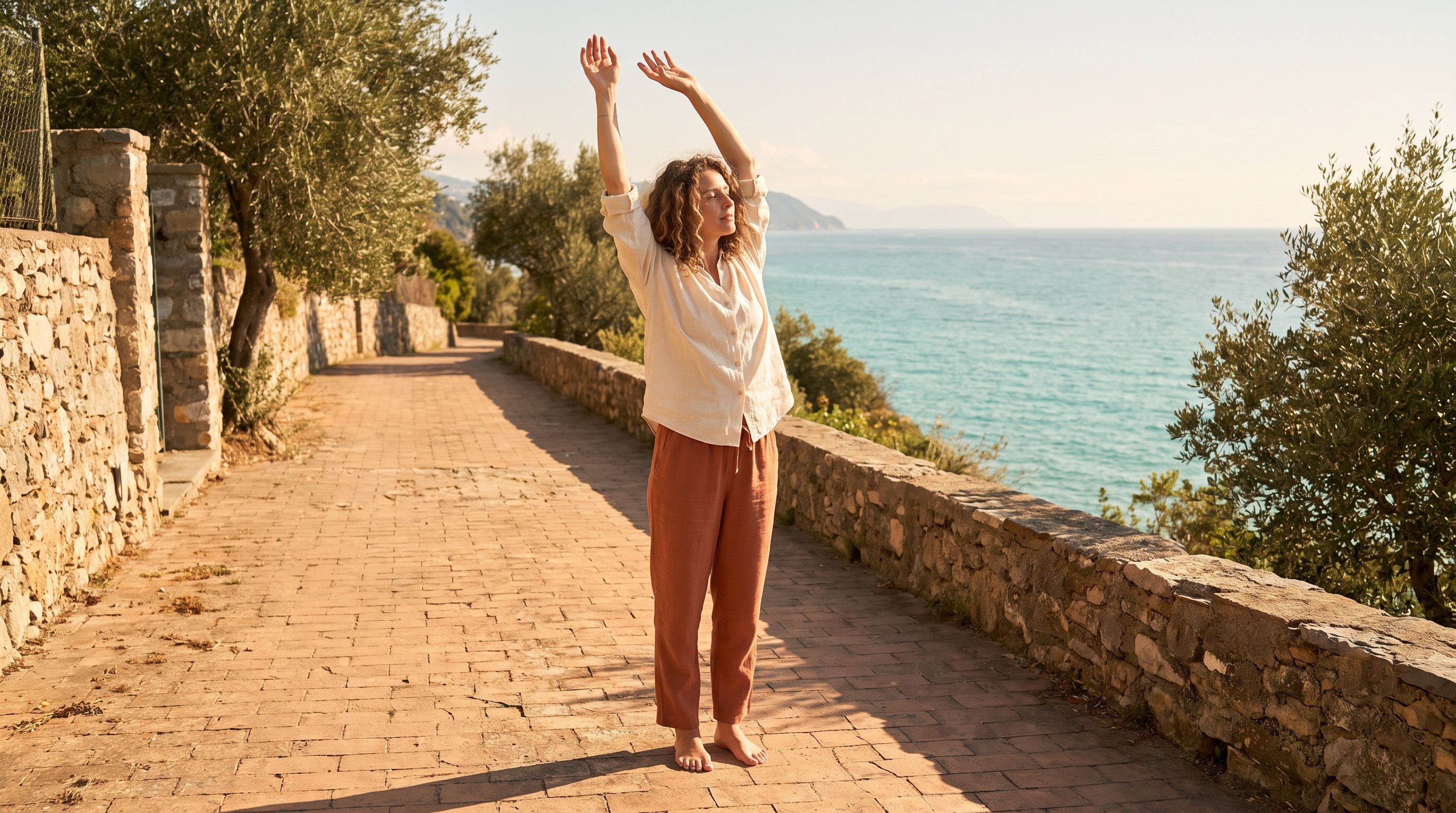 person stretching arms overhead beside a sunlit window person stretching arms overhead beside a sunlit window