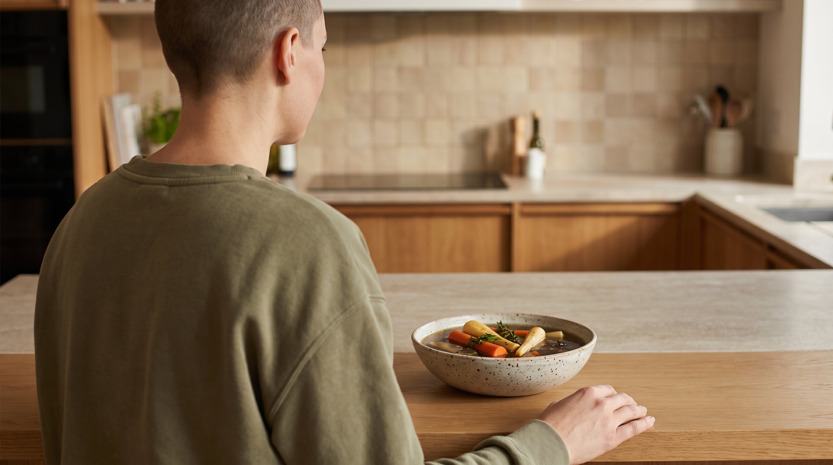 bowl of bone broth with vegetables on a kitchen counter